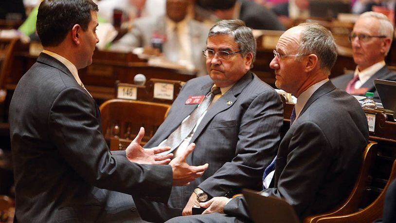 Terry Chastain, left, general council for the House Speaker's office, talks with Reps. Richard Smith (R-Columbus) and Allen Peake about how to try to get Peake's medical marijuana bill passed as the last day of the legislative session ticks towards a close Thursday evening, March 20, 2014.