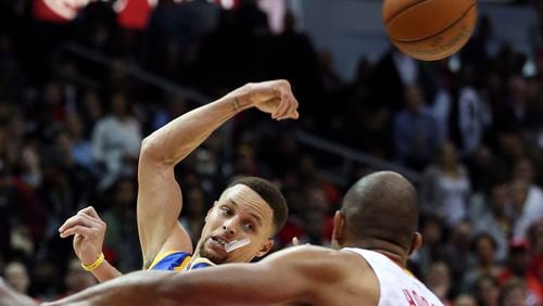 Golden State Warriors guard Stephen Curry (30) passes as Atlanta Hawks center Al Horford (15) defends in the second half of an NBA basketball game Monday, Feb. 22, 2016, in Atlanta. Golden State won 102-92. (AP Photo/John Bazemore)