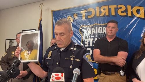 Indiana State Police spokesman Sgt. Carey Huls holds up a photo of Dejuane Ludie Anderson, 37, of Atlanta, who is wanted on a murder charge related to the death of her son.