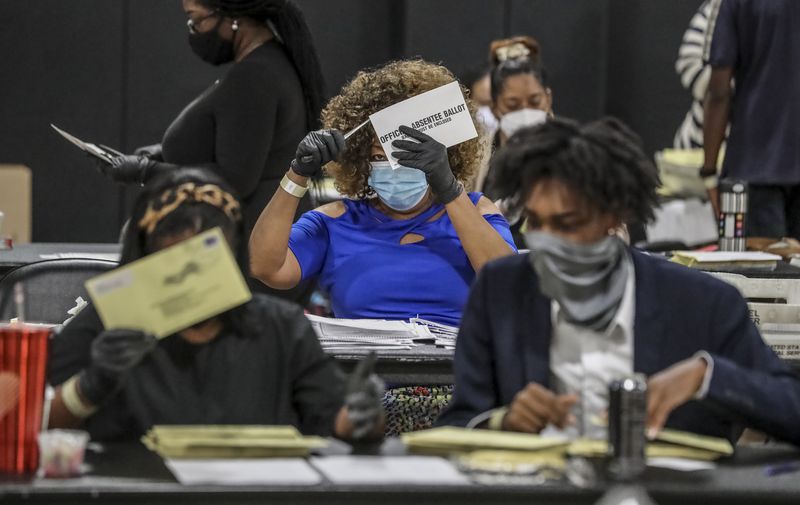 Fulton County Registration and Election Board workers process absentee ballots during the state's primary runoff earlier this month. JOHN SPINK/JSPINK@AJC.COM

