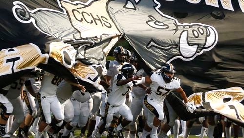 Colquitt County players break through their banner at the start of a high school football Sept. 21, 2018, at Grayson High School in Loganville.