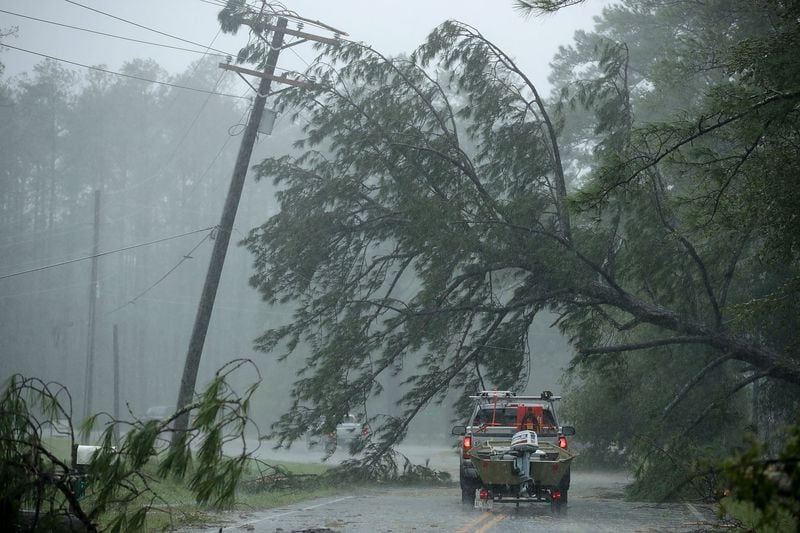  A volunteer rescue truck drives underneath a fallen tree that is suspended by power lines blown down by Hurricane Florence on Friday in New Bern, N.C.   (Photo: Chip Somodevilla/Getty Images)