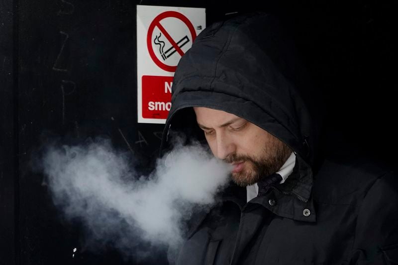 A man smokes on a street, in London, Tuesday, April 16, 2024. A bold plan to ban anyone born after 2008 from ever legally buying cigarettes in Britain faces its first test in Parliament. The bold plan has divided the governing Conservatives, with some hailing its public health benefits and others condemning it as state overreach. (AP Photo/Kin Cheung)
