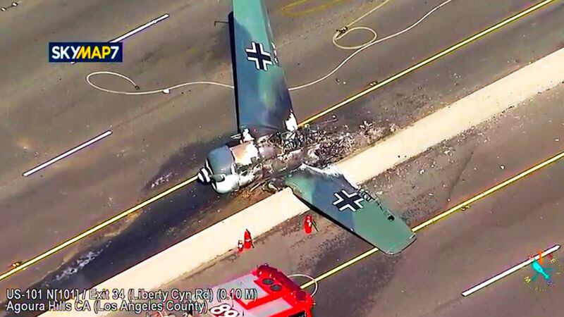 This photo taken from video provided by KABC-TV shows a vintage North American AT-6 airplane that crashed on U.S. 101 in Agoura Hills, Calif., Tuesday, Oct. 23, 2018. The pilot escaped uninjured and no one on the ground was hurt. The crash snarled traffic about 30 miles (50 kilometers) west of downtown Los Angeles.