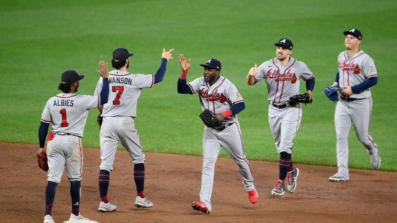 Atlanta Braves' Ozzie Albies (1), Dansby Swanson (7), Guillermo Heredia, third from left, and others celebrate after a baseball game against the Baltimore Orioles, Saturday, Aug. 21, 2021, in Baltimore. (AP Photo/Nick Wass)