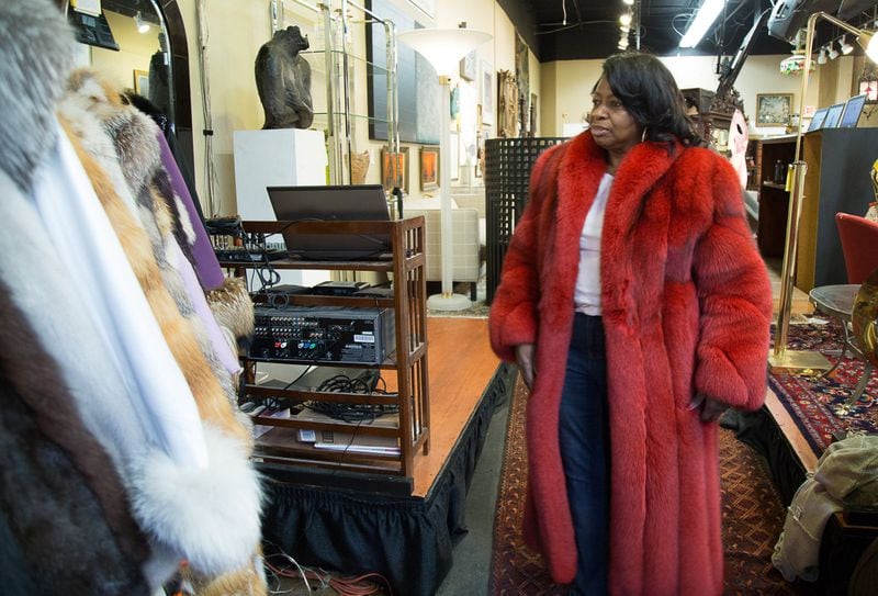 Lynette Gamble tries on a red fur coat before the auction start Saturday at the Ahlers & Ogletree gallery in Atlanta, Ga January 14, 2017. STEVE SCHAEFER / SPECIAL TO THE AJC