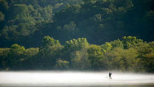 A fisherman paddles through the fog on the Chattahoochee River at Morgan Falls Overlook Park. PHOTO / JASON GETZ
