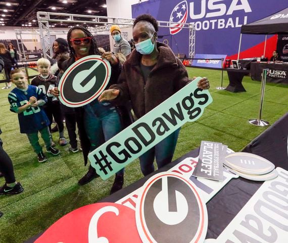 Brittany Jordan (left) and Arielle Jordan, a former UGA student, pick out placards for the 3d photo booth at Fan Central in the Indiana Convention Center at the 2022 College Football Playoff National Championship  between the Georgia Bulldogs and the Alabama Crimson Tide at Lucas Oil Stadium in Indianapolis on Saturday, January 8, 2022.   Bob Andres / robert.andres@ajc.com