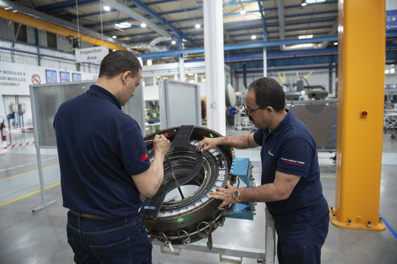 Engineers and workers repair an aircraft part inside Safran Aircraft Engines repair plant outside of Casablanca, Morocco, Thursday, April 18, 2024. Moroccan officials are aiming to turn the country into an aerospace hub, luring investors and manufacturers who have aimed to spread out their supply chains and find willing workers since the COVID-19 pandemic. (AP Photo)