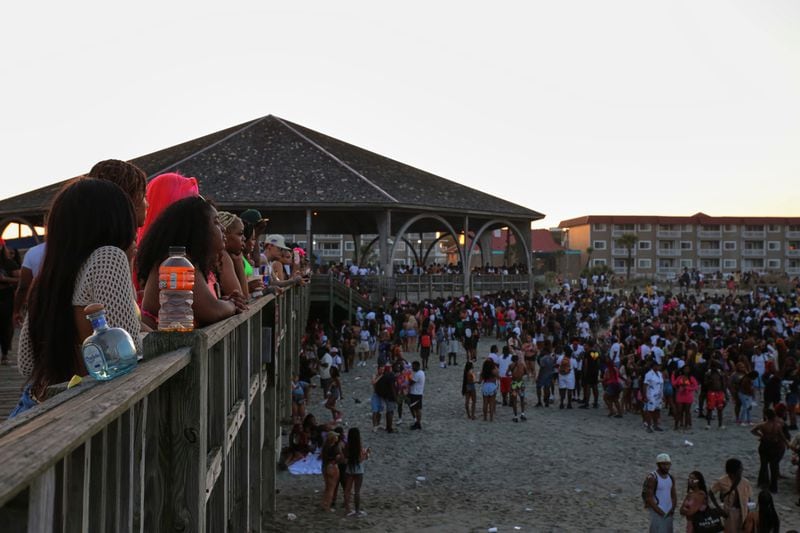 People take a break from partying to watch others from the Tybee Island Pier during Orange Crush on Saturday.