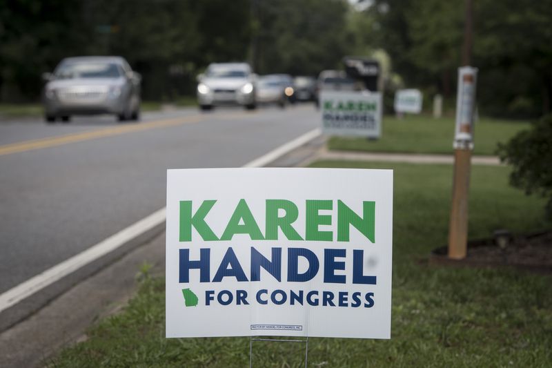 Vikki Thomas's campaign sign for Karen Handel is shown in her yard along with signs belong to her neighbors, Friday, June 2, 2017, in Roswell, Ga. Signs have been stolen in the area, but so far, these have survived. (John Amis)
