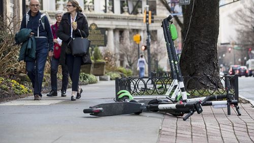 01/04/2019 — Atlanta, Georgia — Pedestrians walk passed Lime and Bird scooters that are parked on the sidewalk of Peachtree Street in Atlanta’s Midtown community, Friday, January 4, 2019. (ALYSSA POINTER/ALYSSA.POINTER@AJC.COM)