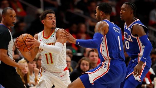 Hawks guard Trae Young looks to pass out of the trap set by Philadelphia's Mike Scott (1) and Josh Richardson (0) during the first half Oct. 28, 2019, at State Farm Arena in Atlanta.