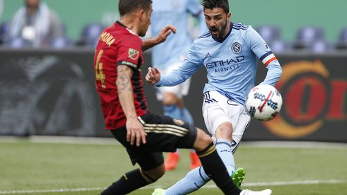 New York City FC forward David Villa (7), of Spain, takes a shot with Atlanta United midfielder Carlos Carmona (14), of Chile, defending during the first half of a Major League Soccer game, Sunday, May 7, 2017, in New York. Villa scored the first goal for New York City FC. (AP Photo/Kathy Willens)