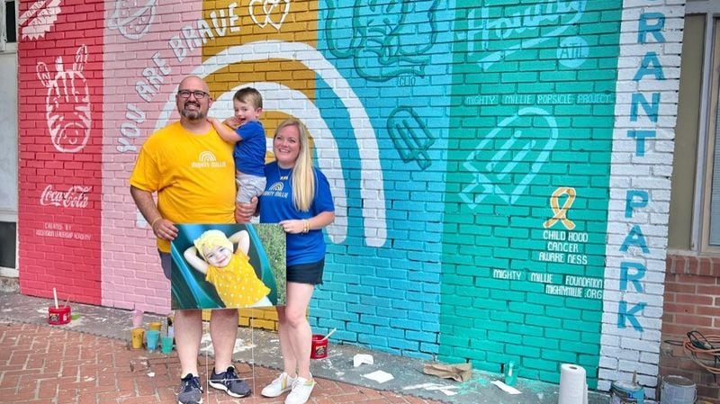 Millie's parents, Nick and Claire Mracek, stand in front of the newly-painted mural.