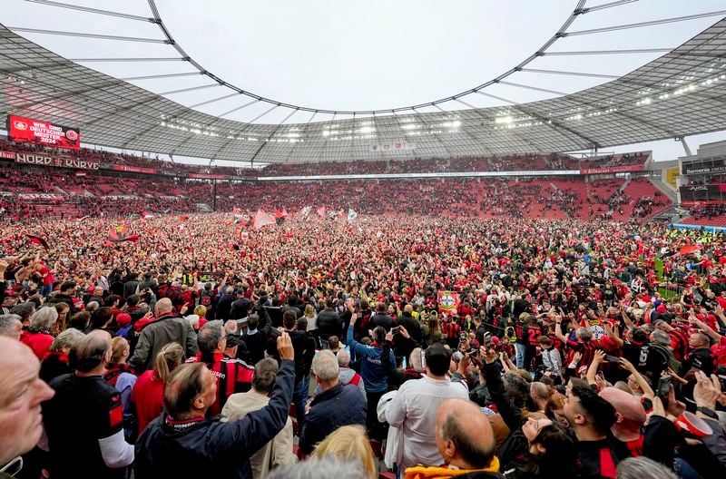 Leverkusen fans run on the pitch after Bayer Leverkusen won the German Bundesliga title beating Werder Bremen in Leverkusen, Germany, Sunday, April 14, 2024. (AP Photo/Martin Meissner)