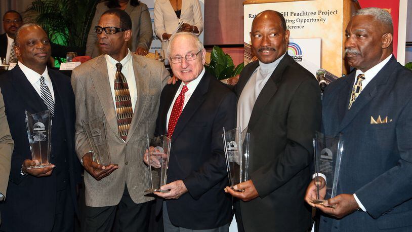 Former Georgia coach Vince Dooley (center) presents Larry West (from left), Richard Appleby, Horace King and Clarence Pope awards from the Rainbow PUSH Coalition honoring them for in 1971 becoming the first black students to play football on scholarship at the institution Saturday, Bo. 2, 2013, at the Hyatt Regency in Atlanta.  (Phil Skinner/AJC)