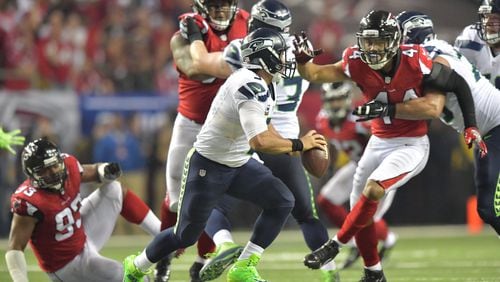 Seattle Seahawks quarterback Russell Wilson (3) moves a ball around to avoid a tackled by Atlanta Falcons outside linebacker Vic Beasley (44) in the second half during the NFC divisional playoffs at the Georgia Dome on Saturday, January 14, 2017. Atlanta Falcons won 36-20 over the Seattle Seahawks. HYOSUB SHIN / HSHIN@AJC.COM