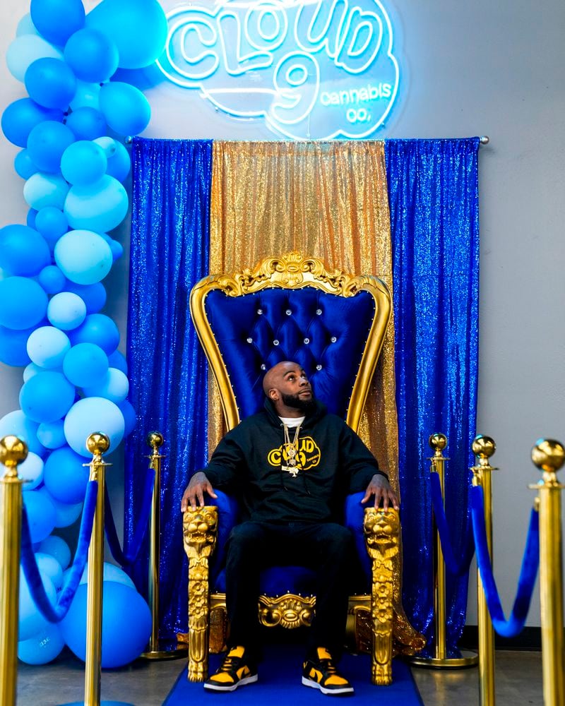 Cloud 9 Cannabis CEO and co-owner Sam Ward Jr. poses in a throne photo-op for customers, Saturday, April 13, 2024, in Arlington, Wash. The shop is one of the first dispensaries to open under the Washington Liquor and Cannabis Board's social equity program, established in efforts to remedy some of the disproportionate effects marijuana prohibition had on communities of color. (AP Photo/Lindsey Wasson)
