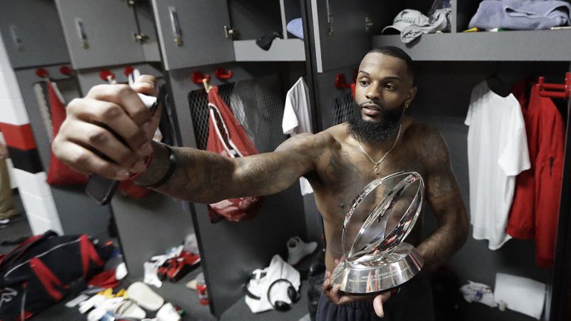  Atlanta Falcons' Justin Hardy takes a selfie with the George Halas Trophy after the NFL football NFC championship game against the Green Bay Packers Sunday, Jan. 22, 2017, in Atlanta. The Falcons won 44-21 to advance to Super Bowl LI. (David J. Phillip/AP)