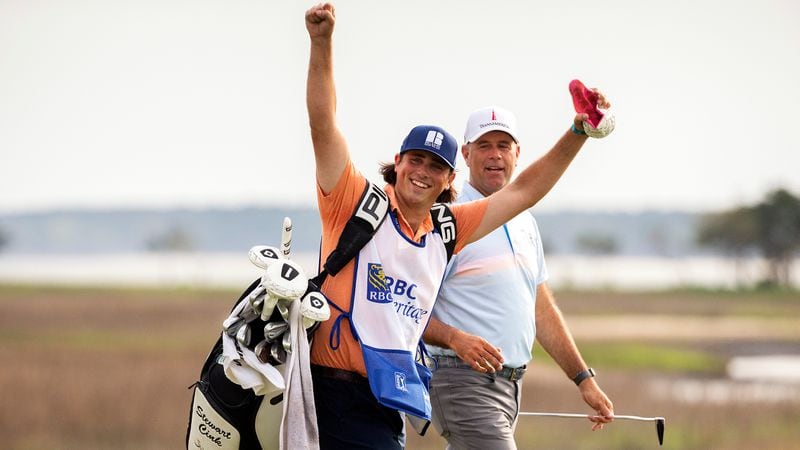 Reagan Cink (left) raises his arms to the crowd while walking with his father, Stewart Cink, up the 18th fairway to the green during the final round of the RBC Heritage golf tournament Sunday, April 18, 2021, in Hilton Head Island, S.C. Stewart Cink won the tournament for a third time. (Stephen B. Morton/AP)