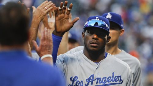 Los Angeles Dodgers right fielder Yasiel Puig (66) high-fives teammates after the Dodgers defeated the New York Mets 7-4 in a baseball game, Saturday, Aug. 5, 2017, in New York. (AP Photo/Julie Jacobson)