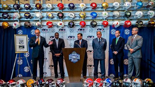 SEC Commissioner Greg Sankey (left) answers questions Tuesday during the press conference announcing a 10-year deal at the College Football Hall of Fame in Atlanta to play the SEC Championship game at Mercedes-Benz Stadium. Sankey was joined on stage with Atlanta Mayor Kasim Reed (second from left), Atlanta Falcons owner Arthur Blank (third right) and other officials.