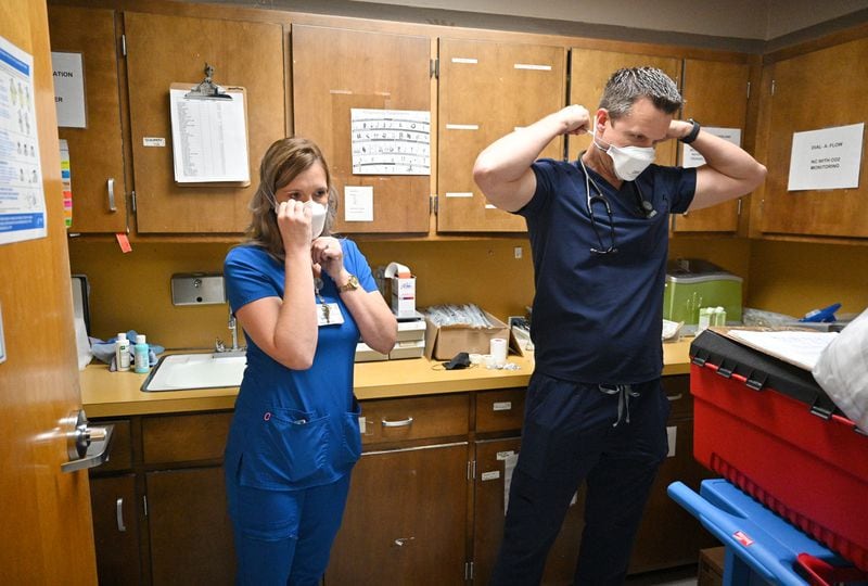 Dr. Jason Laney, right, and charge nurse Sarah Spell put on PPE in an intensive care unit at Jeff Davis Hospital in Hazlehurst on Monday. (Hyosub Shin / Hyosub.Shin@ajc.com)