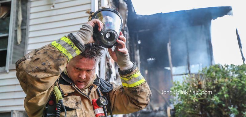 Atlanta fire Sgt. Hayne Palmer removes his mask after containing a house fire in the Pittsburgh neighborhood of Atlanta. JOHN SPINK / JSPINK@AJC.COM