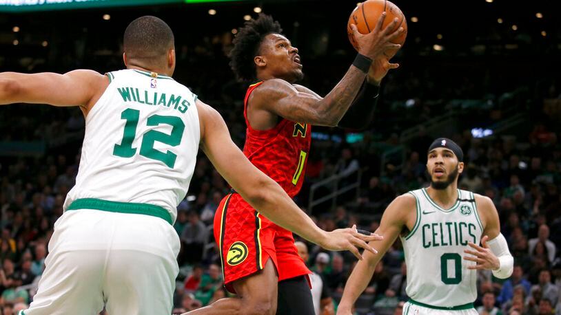 Hawks guard Brandon Goodwin drives to the basket between Boston Celtics forward Grant Williams (12) and forward Jayson Tatum (0) during the second half of an NBA basketball game, Friday, Feb. 7, 2020, in Boston. (AP Photo/Mary Schwalm)