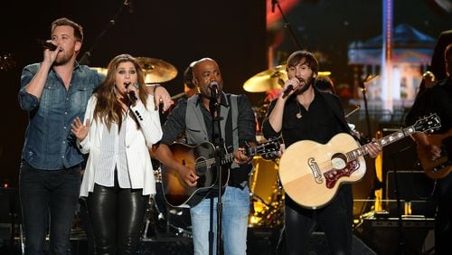 Members of Lady Antebellum sing with Darius Rucker (second from right). The trio is going on tour with Rucker this summer.