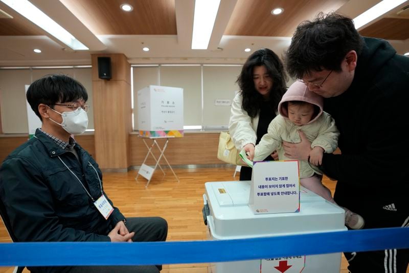 A family casts their votes for the parliamentary election at a polling station in Seoul, South Korea, Wednesday, April 10, 2024. South Korean President Yoon Suk Yeol faces a crucial referendum Wednesday in a parliamentary election that could determine whether he becomes a lame duck or enjoys a mandate to pursue key policies for his remaining three years in office. (AP Photo/Ahn Young-joon)