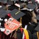 Graduates - including one with a message for mom - wait for the Clark Atlanta University commencement ceremony to start in Panther Stadium on Saturday, May 20, 2023.   (Steve Schaefer/steve.schaefer@ajc.com)