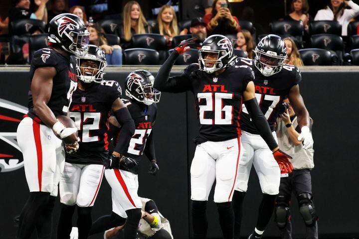 Falcons players celebrate with linebacker Lorenzo Carter after Carter intercepted a pass and scored a touchdown during the second quarter against the Panthers on Sunday in Atlanta. (Miguel Martinez / miguel.martinezjimenez@ajc.com)
