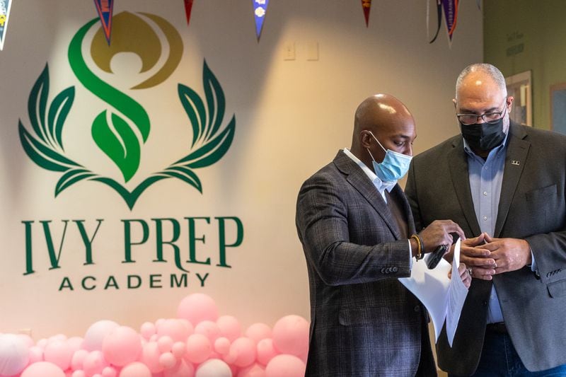 Members of 100 Black Men, including Joshua Byrd, left, and Executive Director Louis Negron, right, participate in a mentor program at Ivy Prep Academy aimed at preventing gun violence on Wednesday, March 16, 2022.  The program provides several weeks of after-school education in conflict resolution, personal choices, social media pitfalls and offers a student billboard competition while spreading awareness of gun violence.  (Jenni Girtman for The Atlanta Journal Constitution)