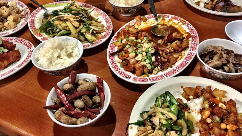 Dishes of vegetable chow mein, kung pao chicken, and salt and pepper squid are served family style at Double Dragon. CONTRIBUTED BY WYATT WILLIAMS
