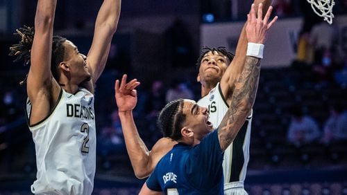 Georgia Tech guard Michael Devoe (middle) shoots under defense from Wake Forest forward Ody Oguama, right, during an NCAA college basketball game Friday, March 5, 2021, in Winston-Salem, N.C. (Andrew Dye/The Winston-Salem Journal via AP)