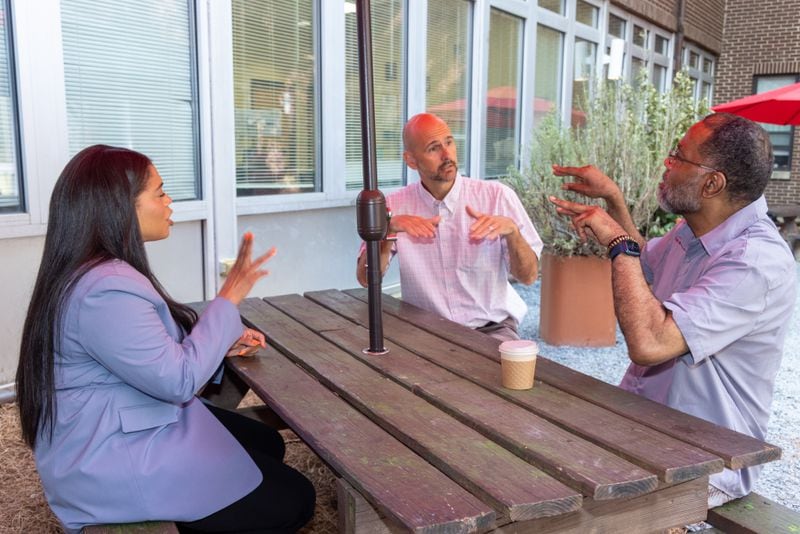 Ivy Porter-Henderson (from left), Kevin Henderson and Bradley Porter chat using sign language in the Hope House courtyard in Atlanta. 
PHIL SKINNER FOR THE ATLANTA JOURNAL-CONSTITUTION.