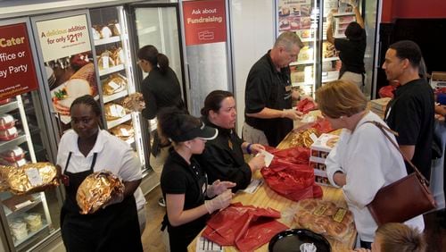 In this Nov. 22, 2011 photo, customers line the counter (right) as employees are in constant motion fetching hams. Honeybaked Ham is synonymous with the holidays, and the day before Thanksgiving we visited one of its busiest stores, at Akers Mill in Atlanta.