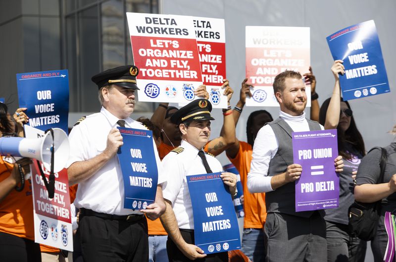 Delta flight attendants, pilots and other demonstrators line the sidewalk and hold signs during the Delta Airlines pro-union flight attendants rally on Thursday, March 25, 2023, at Hartsfield-Jackson airport in Atlanta. Delta employees including flight attendants and pilots as well as other pro-union organizers rallied outside of the airport's south terminal. CHRISTINA MATACOTTA FOR THE ATLANTA JOURNAL-CONSTITUTION.