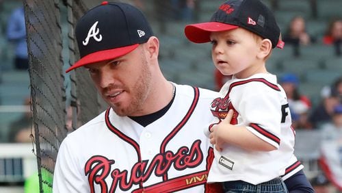 Braves Freddie Freeman holds his son Charlie during a ceremony presenting him with the Wilson defensive player of the year and the Rawlings Gold Gove award before playing the Chicago Cubs Wednesday, April 3, 2019, in Atlanta.