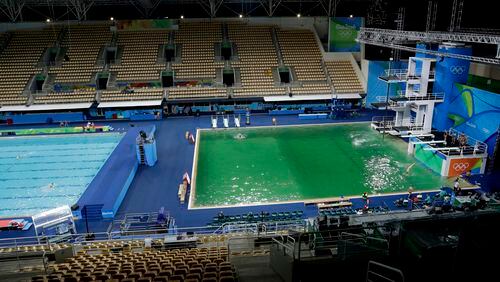 The water of the diving pool at right appears a murky green, in stark contrast to the pool's previous day's color and also that of the clear blue water in the second pool for water polo at the venue as divers train in the Maria Lenk Aquatic Center at the 2016 Summer Olympics in Rio de Janeiro, Brazil, Tuesday, Aug. 9, 2016. (AP Photo/Matt Dunham)