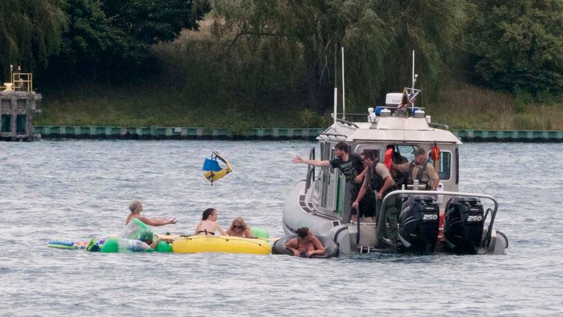 A Customs and Border Protection boat helps floaters during Float Down on the St. Clair River in Port Huron, Mich., Sunday, Aug. 21, 2016. The west winds blew most boaters toward the Canada shore and they had to be pulled back to the U.S. Thousands were expected to take part in Port Huron Float Down. (Mark R. Rummel/The Times Herald via AP)