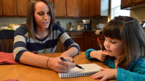 Ashley Cline helps her daughter, Avery,4, with a handwriting exercise at their home in Canton. Cline is the wife of a public school teacher who is speaking out against Georgia’s new health care plan for state employees. Avery attends occupational therapy for help developing her fine motor skills. Under the new plan the cost went from $25.00 to $130.00. BRANT SANDERLIN /BSANDERLIN@AJC.COM