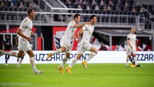 Atlanta United's Adam Jahn (from left), Jon Gallagher and Brooks Lennon celebrate a goal in 4-0 defeat of D.C. United Saturday, Oct. 4, 2020, in Washington, D.C.