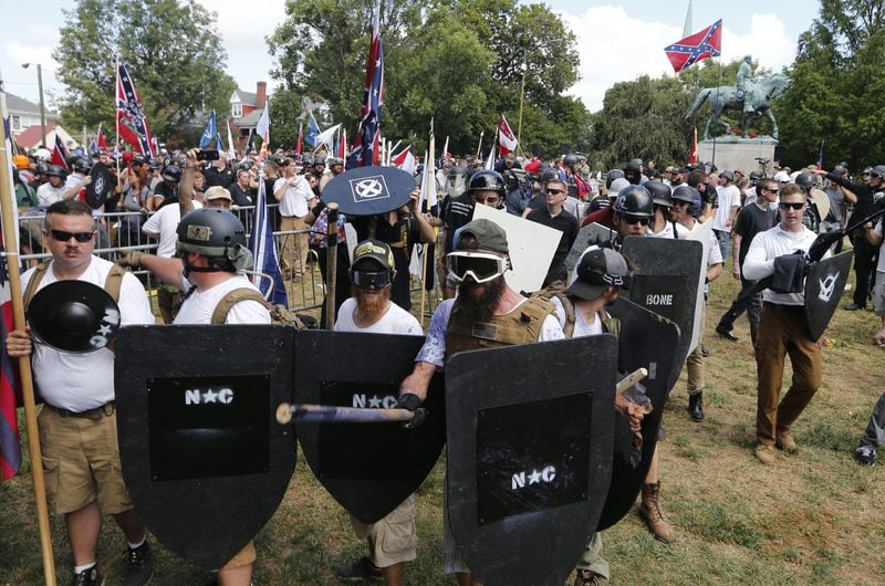 This Aug. 12, 2017, photo shows white nationalist demonstrators holding their ground as they clash with counter demonstrators in Lee Park in Charlottesville, Va. Authorities have not provided a crowd estimate for the rally that descended into chaos. But two organizations that track hate groups and were monitoring the event said it was the largest white supremacist gathering in a decade or more. (AP Photo/Steve Helber)