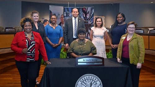 Atlanta Public Schools Superintendent Lisa Herring (center) is pictured with board members after her swearing-in ceremony in July. The district's leaders will host a series of community talks in March. (Hyosub Shin / AJC FILE PHOTO)