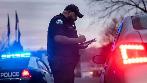 Feb. 7, 2017 - A Roswell police officer talks to a resident at an apartment complex where a 17-year-old boy was found shot and killed early Tuesday in Roswell. BRANDEN CAMP/SPECIAL