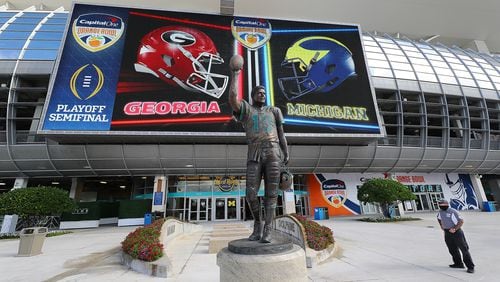 A security guard stands next to the statue of iconic Dolphins quarterback Dan Marino at Hard Rock Stadium on Wednesday, Dec 29, 2021,  where Georgia will play Michigan in the Orange Bowl CFP Semifinal in Miami Gardens. On the evening of September 17, 2000, during halftime of their nationally-televised game with the Baltimore Ravens, the Dolphins retired Marino's jersey number and unveiled the statue of him permanently placed outside Pro Player Stadium (now Hard Rock Stadium).  “Curtis Compton / Curtis.Compton@ajc.com”`