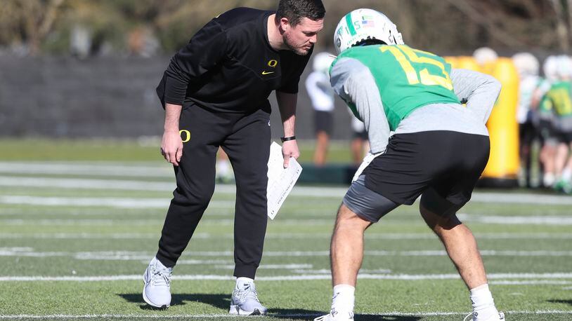 Oregon coach Dan Lanning demonstrates to defensive players how he wants them to line up at a practice last spring in Eugene, Ore. (Rob Moseley/GoDucks.com)